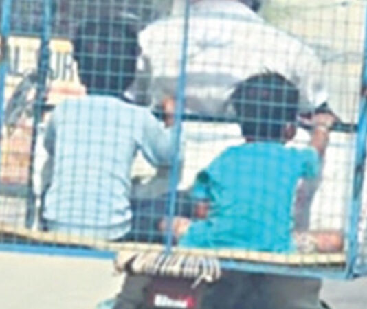 கோழிக்கூண்டில் அமர்ந்து தந்தை பைக்கில் பயணித்த மகன்கள்